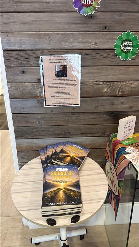 Livres de Tania Dalia Kiboko exposés au bureau à côté de l'affiche de reconnaissance